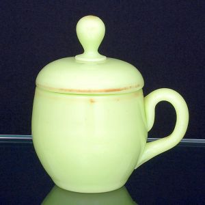 <b>Xícara com tampa </b>em opalina francesa verde claro apresentando forma bojuda com alça recurvada. Séc. XIX. Alt. 13,5 cm; Compr. 13 cm