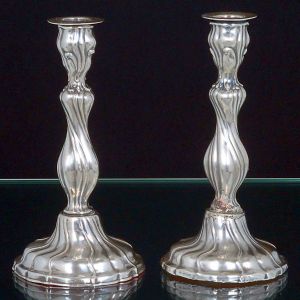 <B>Par de castiçais </B>em prata alemã, teor 925 ml. Decoração em retorcidos. Possui lastro. Prateiro WB. Alt. 19,5 cm