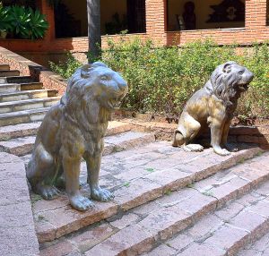 <b>Par de esculturas </b>em bronze patinado representando casal de leões sentados. Alt. 114 cm.