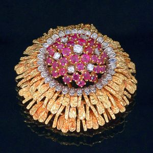 <b>Broche </b>de rubis e diamantes montados em ouro 18k com 37 rubis redondos e 39 diamantes, 7 "full brilliant cut" e 32 8/8 (single cut), 7 no centro e 32 em torno do centro da peça. Peso da peça 27,47 gramas.