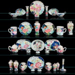 <b>Serviço do Marquês de Vila Real da Praia Grande</b> - (Caetano Pinto de Miranda Montenegro) - Grande conjunto de jantar e mesa em porcelana Companhia das Índias riquissimamente decorada em policromia no conhecido padrão "Folha de Tabaco". Decoração com inspiração na vegetação luxuriante do sudeste asiático e das ilhas do oceano pacífico apresentando em primeiro plano flor de hibisco, figuras de fênix, esquilos, frutos, flores e folhas. Reinado Qianlong. Séc. XVIII. Constando de 27 pratos rasos (22 cm), 9 pratos fundos (23 cm), 3 sopeiras maiores (36cm) com seus respectivos "presentoirs" (37,5 cm), 1 sopeira menor (29 cm) com seu respectivo "presentoir" (31 cm), 1 sopeirinha p/ molho (19 cm) c/ "presentoir" (20,5 cm), 1 terrina p/ molho (19 cm) e covilhete folha (20,5 cm), 4 pares de grandes travessas (48, 46, 46 e 43 cm), 3 pares de travessas menores (34,5, 34 e 28 cm), 4 travessas (43, 38,5, 31 e 31 cm), 1 travessa funda (38 cm), 1 par de molheiras (20 cm), 1 covilhete recortado (29 cm), 2 pares de covilhetes (22  e 20,5 cm), 1 par de "réchauds" (28 cm), 1 cesta fenestrada (25 cm), 3 pares de saleiros (10 cm), 1 par de vasos corneta (18,5 cm), 2 pares de potiches c/ tampas de prata (17,5  e 13,5 cm), 1 potiche c/ tampa de prata (25 cm), 1 castiçal (21 cm), 1 caixa de chá c/ tampa de prata (11,5 cm), 2 canecas (15 e 14 cm), 1 bule folha (15 cm), 1 bule (13,5 cm), 4 xícaras c/ pires, 1 xícara c/ alças e pires, 1 pequeno "bowl"  c/ pires e 5 pequenos "bowls" (8 cm). Total de 110 peças.