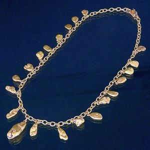 <b>Colar </b>em ouro 18k, modelo articulado com elos ovais, apresentando 21 pepitas de ouro como pingentes, distribuídos ao longo de toda a extensão. Fecho tipo gaveta com trava de segurança. Peso 158 gramas.