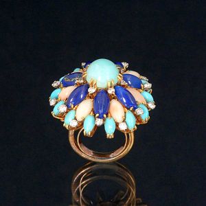 <b>Anel </b>criação de Lucien Finkelsteinn montado em ouro 18k com 15 turquesas e 7 lápis lazúlis e 20 brilhantes redondos "full brilliant cut", 7 corais brancos. Peso total da peça 22,82 gramas.