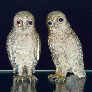 <b>Conjunto de saleiro e pimenteiro</b> em metal espessurado a prata, em forma de corujas com olhos em contas. Apresenta punção de fabricante não identificada. Alt. 13,5 cm