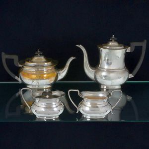 <b>Serviço para chá e café </b>em metal Sheffield, apresentando decoração lisa com alças e pegas das tampas em madeira. Constando de bules p/ chá e café, leiteira e açucareiro. Marca do fabricante no verso.