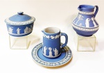 Wedgwood blue Jasperware - quatro antigas peças com decoração em relevo de figuras femininas e querubins. Uma mantegueira com 10 cm de diâmetro e 9 de altura, 1 leiteira de 13 cm, 1 cremeira com 10 cm e 1 prato de 14 cm.