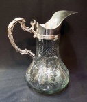 Elegante jarra estilo Art Nouveau, francesa em cristal lapidado a mão de base em estrelas. Metal espessurado a prata com detalhes cinzelados, alça recurva. Altura de 24 cm e base de 12 cm.