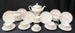 Conjunto de fina porcelana Epiag "Checoslováquia" na cor marfim vitrificada e delicadamente decorada com flores na tonalidade salmom e bege tendo bordas onduladas e filetadas em dourado. Contém: 1 bule de chá de 16 cm, 6 xícaras de chá de 6 cm e 5 pires, 6 pratos de servir com 17 cm, 1 xícara de café de 4,5 cm e 2 pires de café, 1 leiteira de 12 cm de altura e 1 cremeira com 8 cm.  Obs: 1 prato de servir com pequeno fio de cabelo.