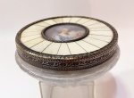 Belíssima caixa p/ pó de arroz em grosso cristal lapidado de tampa decorada com dama estilo Victoriano. Em rococó e detalhes em placas na cor marfim com acabamento em bronze dourado cinzelado. Aplicador em lã.  Mede 12 cm de diâmetro e 5 cm de altura. Obs: espelho interno com trinca.