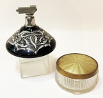 Duas peças de toucador antigas, sendo um perfumeiro em vidro negro de Murano com aplicações de esmalte branco em laços, treliças e arabescos. Acabamento em metal prateado (sem a bombinha) e uma caixa em cristal Europeu fosco com nervuras e tulipas tendo tampa c/ nacarado dourado ondeado. Perfumeiro de 9 cm de altura e base de 11 cm. Caixa com 5 cm de altura e 9 cm de diâmetro.