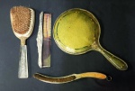 Conjunto de 4 peças de toucador antigas da década de 20 tendo 1 espelho redondo bisotado aro de metal e acetato amarelo, mede 15 cm e comprimento de 27 cm, no estado - 1 escova de cerdas naturais, cabo de metal em curva dourado com 22 cm - 1 pente com detalhes em metal prateado medindo 19 cm e 1 escova com cabo floral translúcido, cerdas naturais com 19 cm.