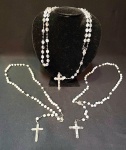 Arte sacra - três antigos rosários sendo 2 em madrepérolas e crucifixos em metal e madrepérola com 45 cm e outro em cristal facetado e irisado com 58 cm.