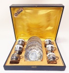 Prata 90 - DOMUS conjunto de xícaras de café em porcelana branca com filete prata, suporte e pires espessurados a prata acondicionados em caixa original, forrada de cetim amarelo. Obs: falta uma xícara. Mede 5 cm.