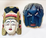 Duas máscaras em madeira esculpidas a mão uma representando Buda em rica policromia c/ dourados e outra Peruana representando Guerreiro (parte superior do cabelo, colado). Buda de 34 x 18 cm e guerreiro de 24 x 20 cm.