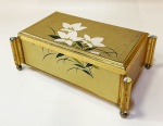 Caixa musical, vintage, em metal dourado tampo em flores e 4 quinas destacadas com arremate em cristal furtacor. Interior em veludo vermelho c/ divisórias. Música: Romance Ve L'Amour. Mede 8 x 10 x 18 cm.