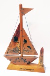 Escultura de jangada, década de 60 em madeira clara com pintura de coqueiros e tubarões com 1 porta lápis ou caneta. Altura de 32 cm e a base com 5 x 20 cm.
