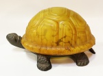 Abalur formato de tartaruga em vidro acidado na cor âmbar fazendo o casco e a estrutura de bronze para as patas e cabeça. Mede 11 de altura e mede 11 x 19 cm.