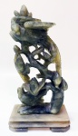 Escultura chinesa em Jade em tronco com pássaros na parte inferior (aves do paraíso). Base retangular em outro ton de Jade. Altura de 17 cm e base de 5 x 9 cm.