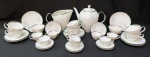 Jogo de chá e café em porcelana Renner branca com detalhes de ramos amarelos e lilás e volutas. Contendo: 8 xícaras de chá de 6 cm de altura, 8 xícaras de café com 4 cm, 1 leiteira com 14 cm, 1 bule com 18 cm. Obs: 1 pires café com bicado na borda e 1 xícara c/ fio de cabelo. 1 xícara de chá com pequena lasca perto da alça. Total de 18 peças.
