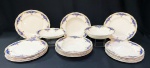 GRINDLEY, England - aparelho de jantar em faiança vitrificada na tonalidade marfim com detalhes em azul cobalto e flor de Lis, bordas douradas. Peças marcadas no fundo. Contém 12 pratos rasos de 23 cm, 6 pratos fundos de 23 cm, 1 travessa funda oval de 5 x 28 x 17 cm e outra com 4 x 15 x 19 cm. Obs: 1 prato raso com pequena lasca na borda.