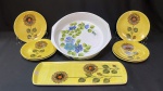Grande travessa funda em porcelana Real, Calorama super refratária em fundo branco pintada a mão em delicadas flores em tons de azul mede 6 x 29 cm e acompanha jogo p/ sobremesa com 1 travessa retangular de 14 x 38 cm e 6 pratos de 18 cm com detalhes amarelos com flor de girassol pintada a mão. Total de 8 peças.