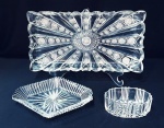 Conjunto para petiscos em cristal lapidado em rosáceas e estrela sendo: 1 bandeja retangular com 2 pequenas faltas no acabamento (imperceptíveis) e 2 porta petiscos um oval e outro losangular.. Oval de 12 x 6 cm e losango de 15 x 21 cm.