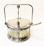 Fracalamza - delicada queijeira em metal espessurado a prata, parte interna em vidro translúcido. Altura de 15 cm e diâmetro de 11 cm.