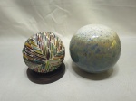 Lote de 2 bolas decorativas, sendo uma em porcelana e uma em cerâmica. Medindo a maior 12cm de altura.