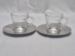 Par de xícaras de café em vidro com pires em inox Design Atelier Oi for Nespresso. Medindo 6cm x 6cm de altura.