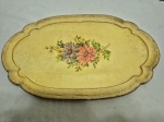 Bandeja oval em madeira patinada com flores ao fundo. Medindo 44cm x 28,5cm.