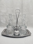 Lote de galheteiro com 5 peças, sendo 2 galhetas em vidro, 2 saleiros em vidro e suporte em aço inox. Medindo a galheta 19,5cm de altura.