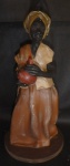 Arte Popular - Escultura Elaborado com barro e biscuit, retratando senhora segurando um cantil - Apresenta quebrado na parte posterior e no braço esquerdo. Alt.21cm