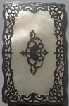 Porta Cartão de Visita em Madre Pérola adornado nas bordas em bronze ricamente trabalhado com decoração no centro. Parte posterior apresenta pequena falta no cato. Med. 6,5 x 10cm.