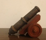 Canhão de ferro forjado sobre base de madeira com roda. Med. 12cm