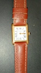 Relogio marca Cartier !! pulseira em couro marrom !! caixa em cor dourada foleado a ouro !! caixa quadrada com numeral em Romanos !! funcionando !!