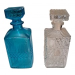 Par de garrafas para whisky em vidro lapidados, uma azul e outra translúcida, Alt. 24 e 22 cm.