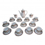 Guarnição para chá em porcelana japonesa Noritake com decoração de flores sobre fundo branco composto de: 1 bule, 1 cremeira, 1 açucareiro e 12 xícaras com pires. Alt 27, Diam. 17  a Alt. A Diam. 10 cm. Total: 15 peças.