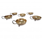 Seis taças para sorvete com bordas repuxadas, interior vermeil e apoiadas em pernas de bola, uma amassada na  borda, 9 x 4 cm.