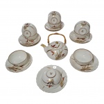 Bule, dez xícaras, nove pires em porcelana oriental com pinturas douradas e vermelhas sobre fundo creme, bordas douradas, 10 x 12 cm.