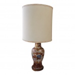 Vaso em porcelana oriental ricamente policromado, adaptado para luminária de mesa, apoiado  em peanha de madeira, cúpula em pergaminho forrado em tecido, acabamento em passamanaria, para uma luz, Alt. 78, Diam. 36 cm.