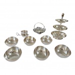 Nove peças espessuradas à prata sendo: um baleiro de 3 níveis, 1 cesta com  borda vasadas e recortadas, 1 porta saquinhos de chá e  6 seis salvas Wolff. Alt. 22, Diam. 13 a  10 cm.
