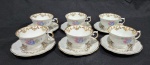 Conjunto de seis xícaras de chá em porcelana nacional da década de 1960, executado ao estilo francês do período Luís XV. Esmaltagem vítrea na cor branca, decorada com motivo vegetalista modelado em relevo na própria pasta, dotado de genorosos arremates em douradura, com frisos, faixas e guirlandas floridas; bojo elipsóide ornamentado, em ambas as faces, com flores em estampagem policromada, asa lateral em voluta coberta por folha de acanto, bordas recortadas. Marca da manufatura no verso. Medindo a xícara 6.5 x 10 x 12 cm e o pires 15 cm