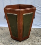 Elegante e antiga lixeira no estilo inglês, com forração em couro e guarnições em metal. Peça selada. Perdas de alguns acabamentos. Medindo 37 x 34.5 x 34,5 cm