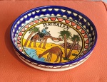 Prato fundo decorativo em cerâmica policromada com camelos e descrição "Jerusalém". Med.: 24cm de diâmetro x 5cm de altura.