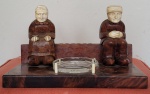 Raro tinteiro europeu do século XIX composto com casal de anciãos esculpido em madeira, cabeça e mãos em marfim, porta-tinta em vidro. Med.: 25x12cm. As esculturas 13cm.