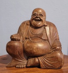 Escultura em madeira maciça de Buda sorridente representa a abundância, alegria, boa fortuna e prosperidade. Med.: 27x25cm