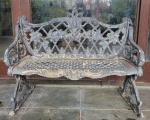 Banco de jardim em ferro estilo vitoriano de dois lugares, apresenta desgastes do tempo na pintura.