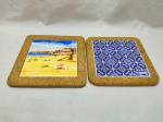 Lote de 2 descansos de panela em cortiça com azulejo ao fundo. Medindo o maior 20,5cm x 20,5cm.