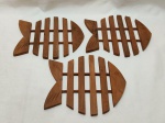 Jogo de 3 descansos de panela em madeira na forma de peixe. Medindo 20,5cm x 18cm de altura.