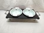 Rechaud com 2 caçarolas ovais em porcelana branca. Medindo 39cm x 26cm x 9cm de altura e a caçarola 26cm x 18cm x 6cm de altura.